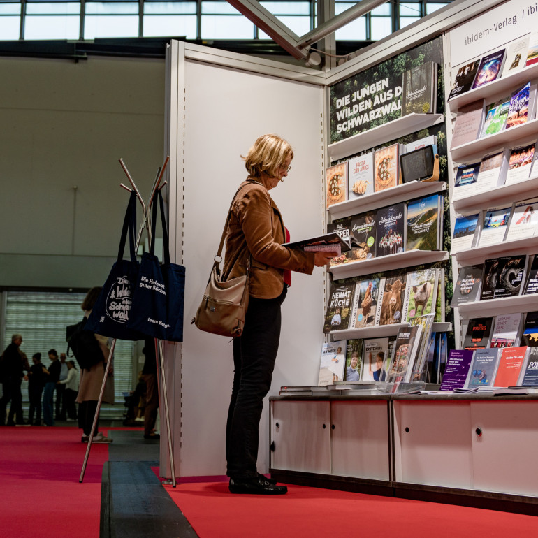 Frau schaut in Bücher auf Frankfurter Buchmesse