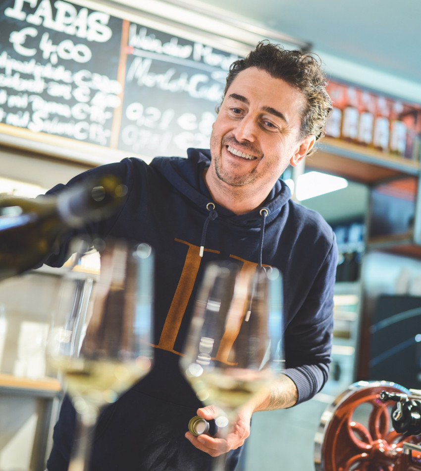 Mann schenkt Wein ein