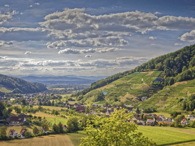 Blick in ein breites Tal mit wolkigem Himmel