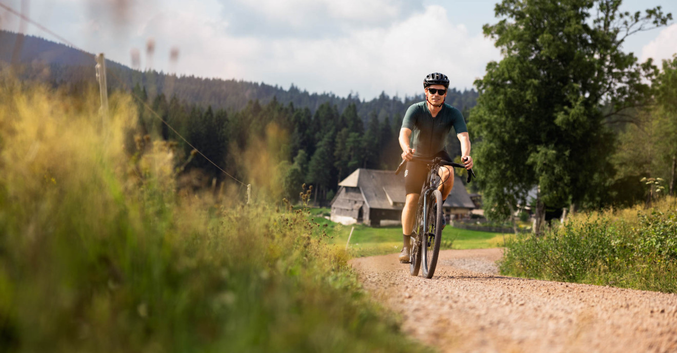 Ein Gravelbike-Fahrer fährt über eine Landstraße.