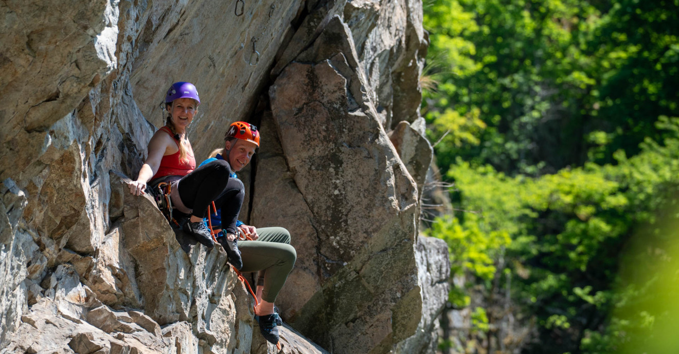 Ein Paar rastet auf einem Klettersteig.