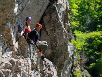 Ein Paar rastet auf einem Klettersteig.
