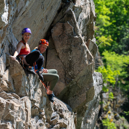 Ein Paar rastet auf einem Klettersteig.