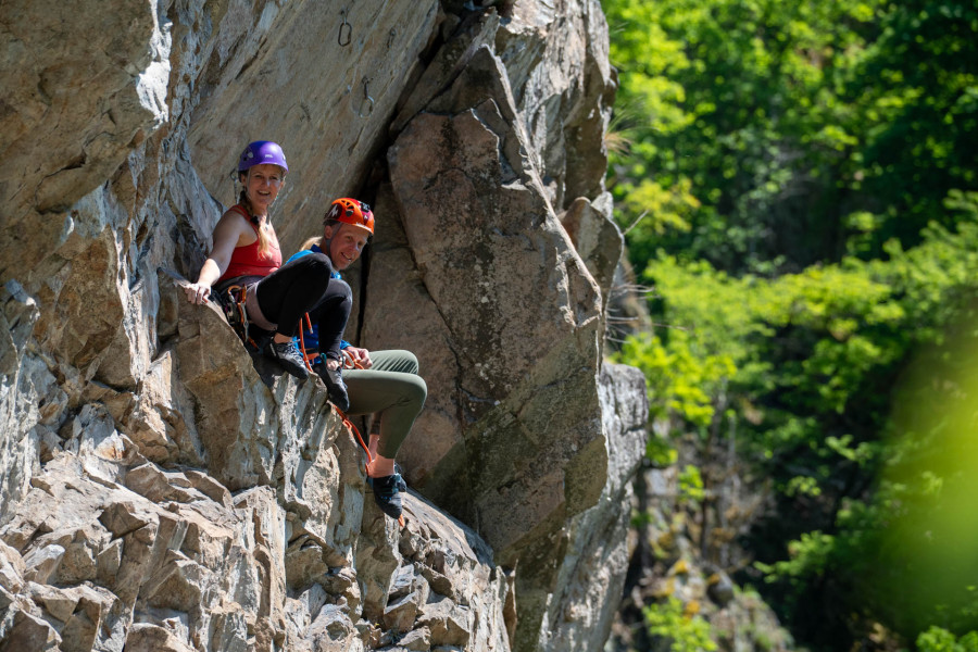 Ein Paar rastet auf einem Klettersteig.