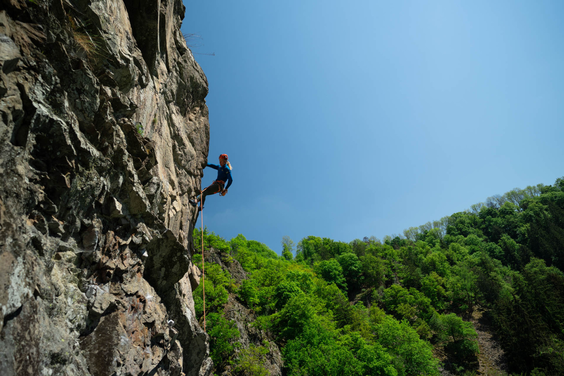 Eine Person seilt sich an einem Felsen ab.