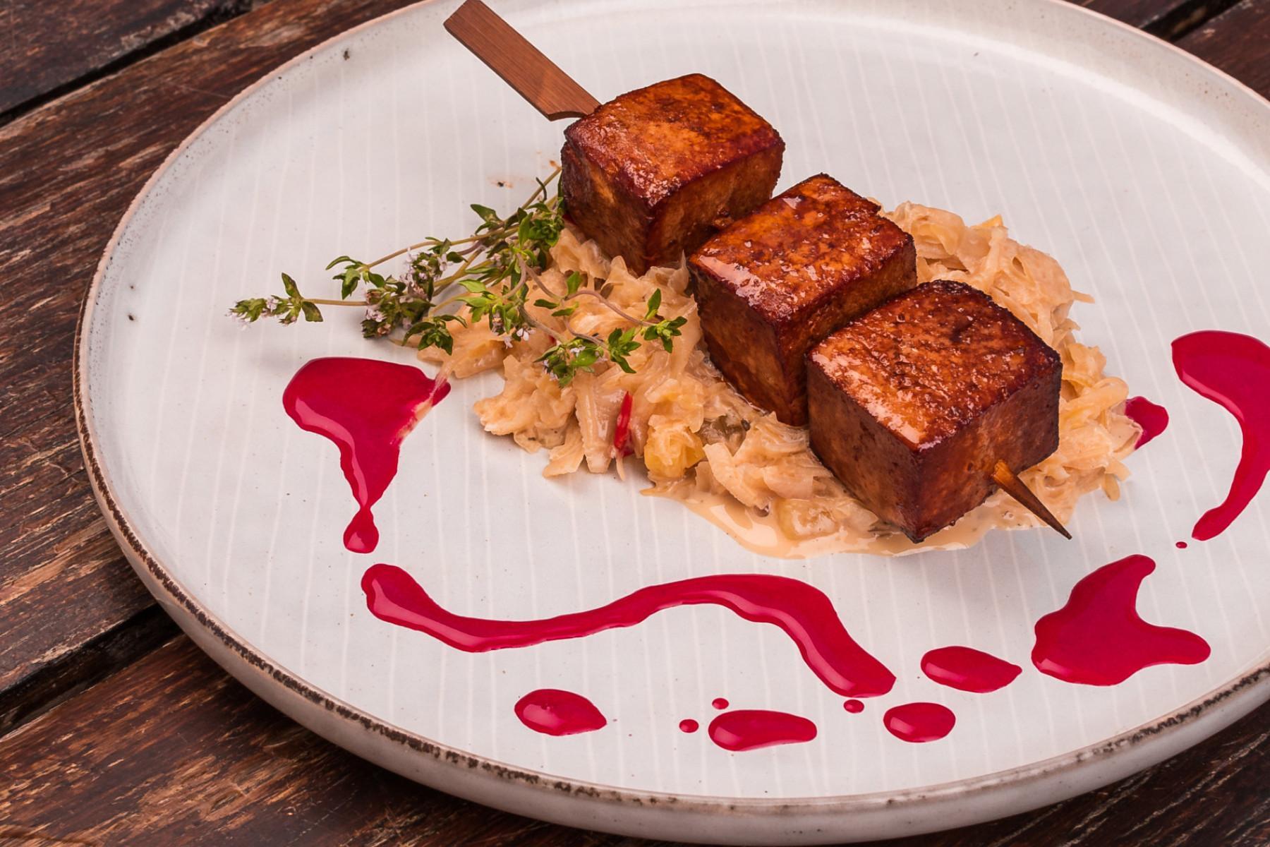 Räuchertofu mit Sauerkraut und Creme auf einem weißen Teller