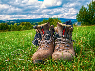 Ein paar Wanderschuhe aus Leder stehen im Gras