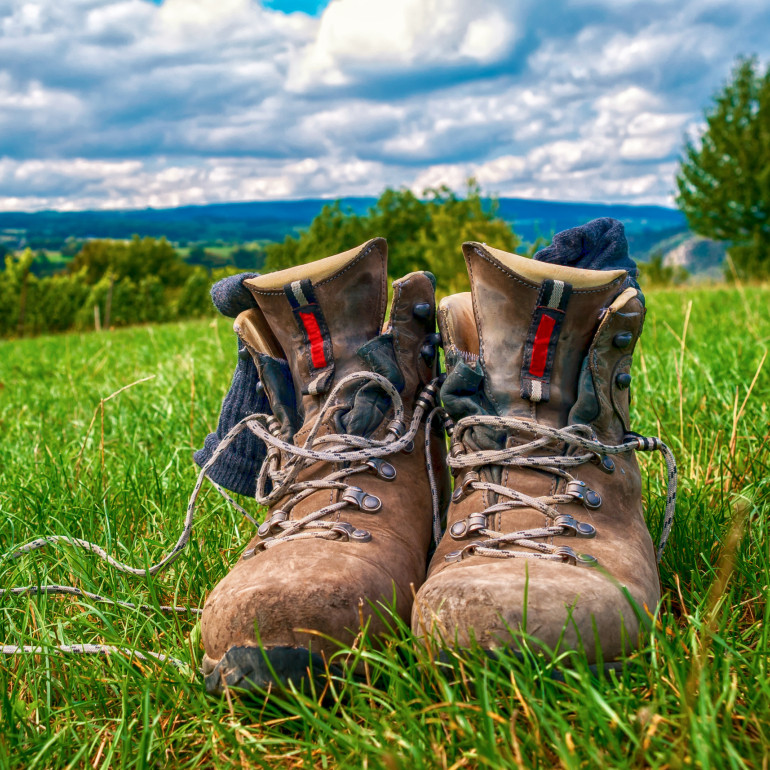 Ein paar Wanderschuhe aus Leder stehen im Gras