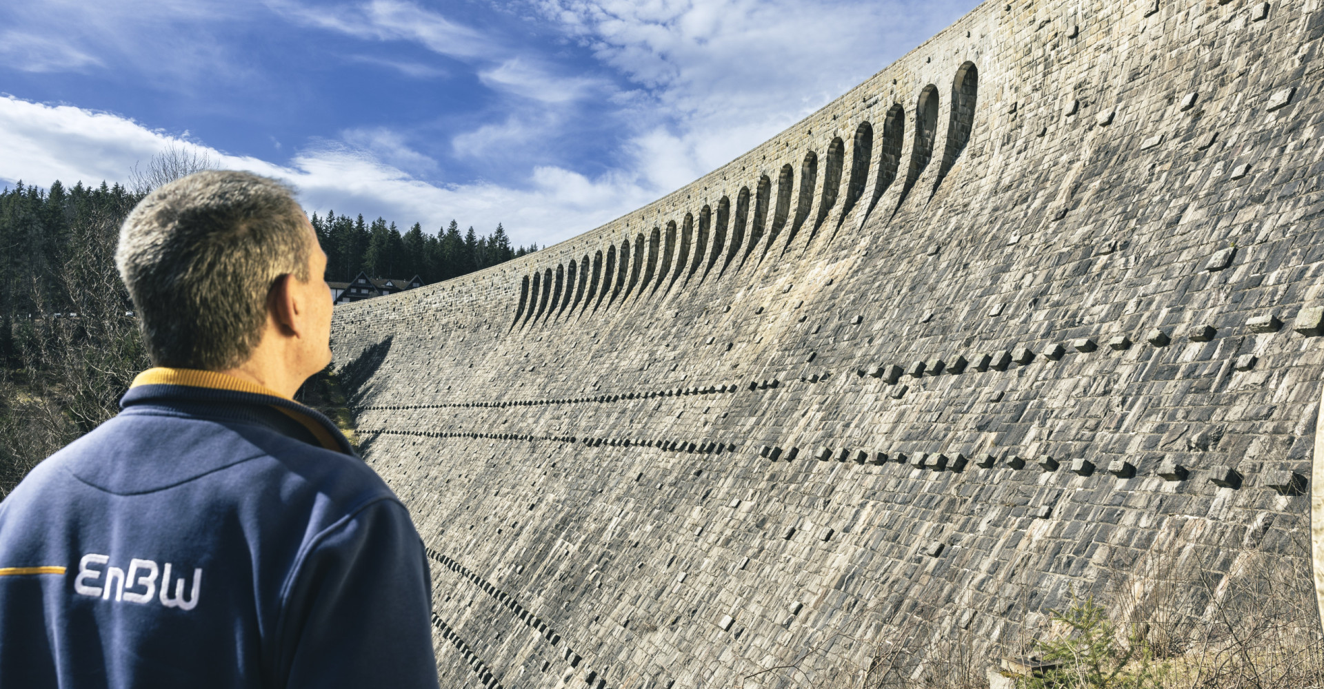 Ein Mann blickt auf die Staumauer in Forbach