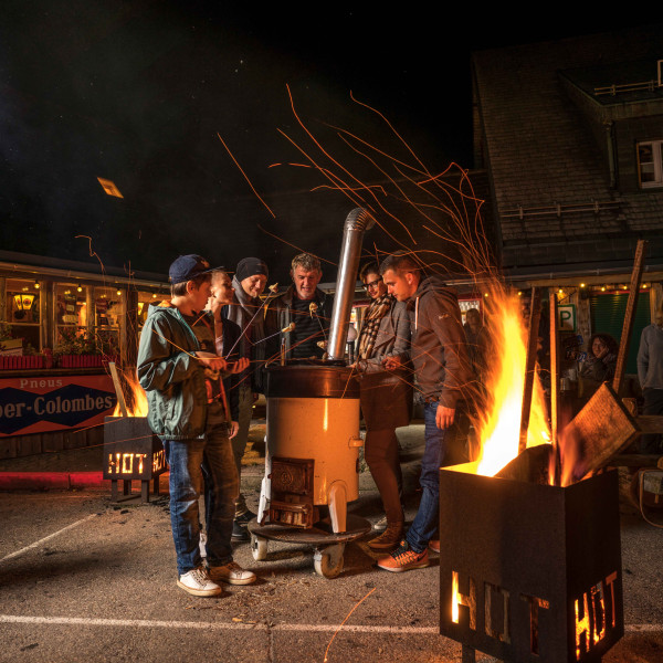 Menschen stehen um ein Outdoor-Käsefondue