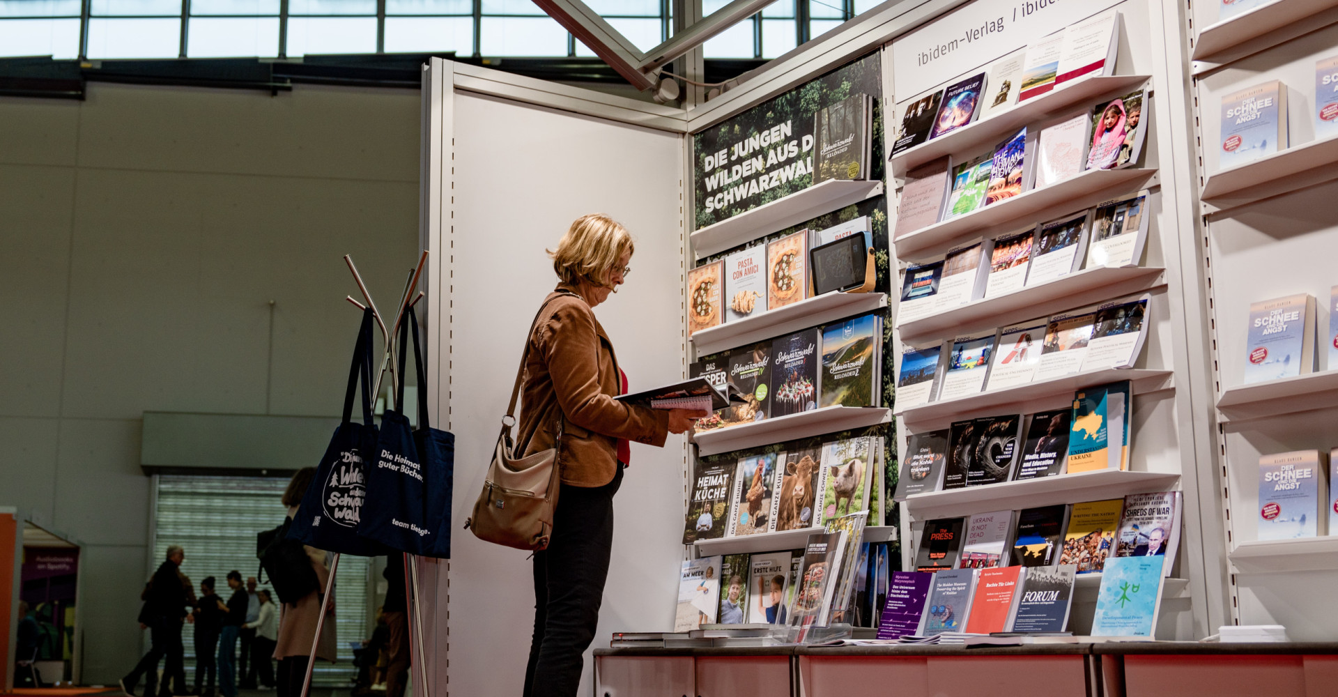 Frau schaut in Bücher auf Frankfurter Buchmesse