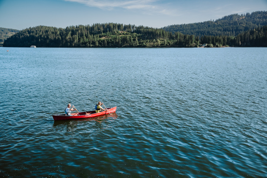 Zwei Menschen im roten Kanu auf dem Schluchsee vor Schwarzwaldkulisse an einem Sommertag