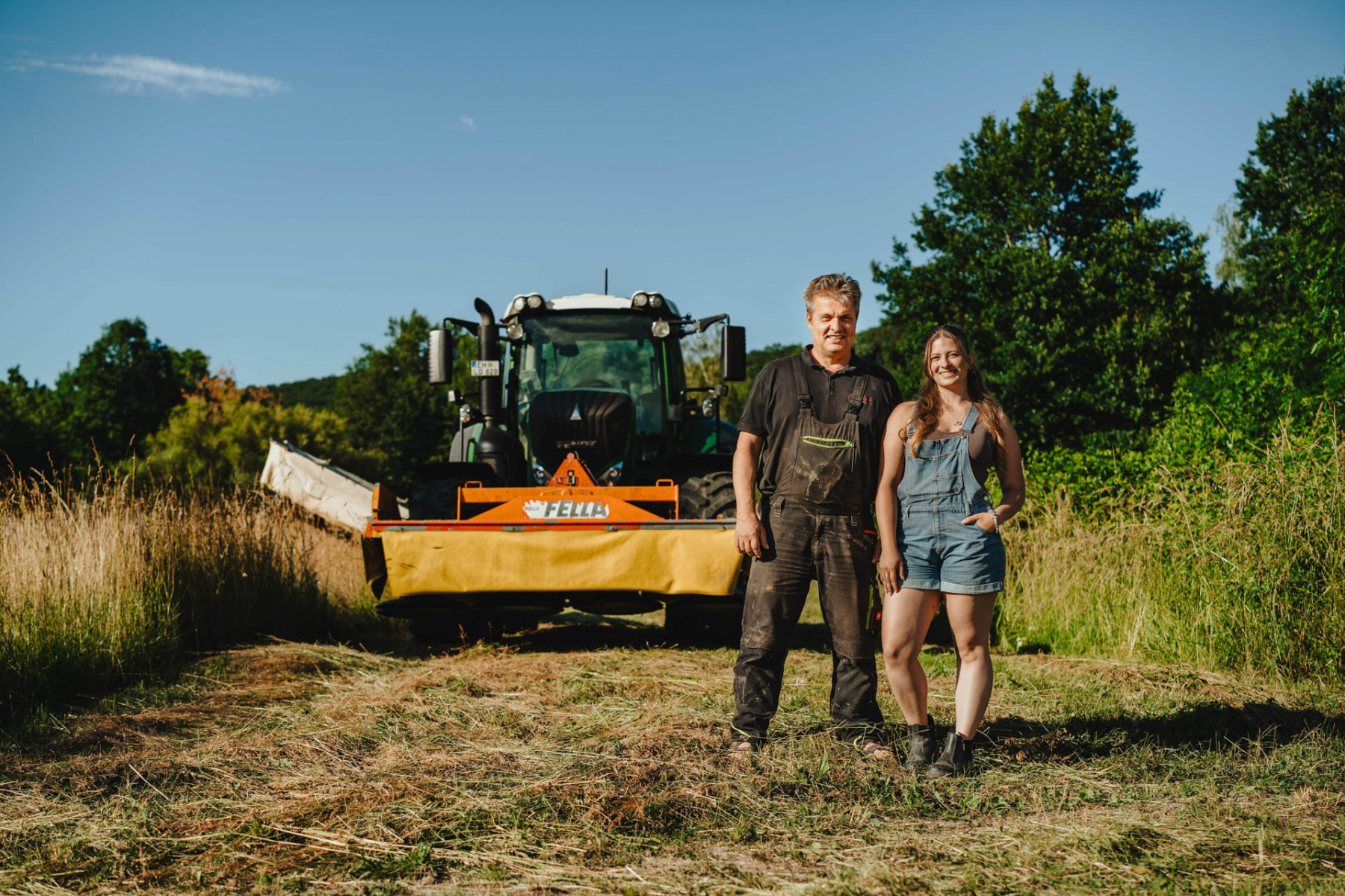 Lisa Dinger und ihr Vater stehen im Feld zwischen Pflanzen. 