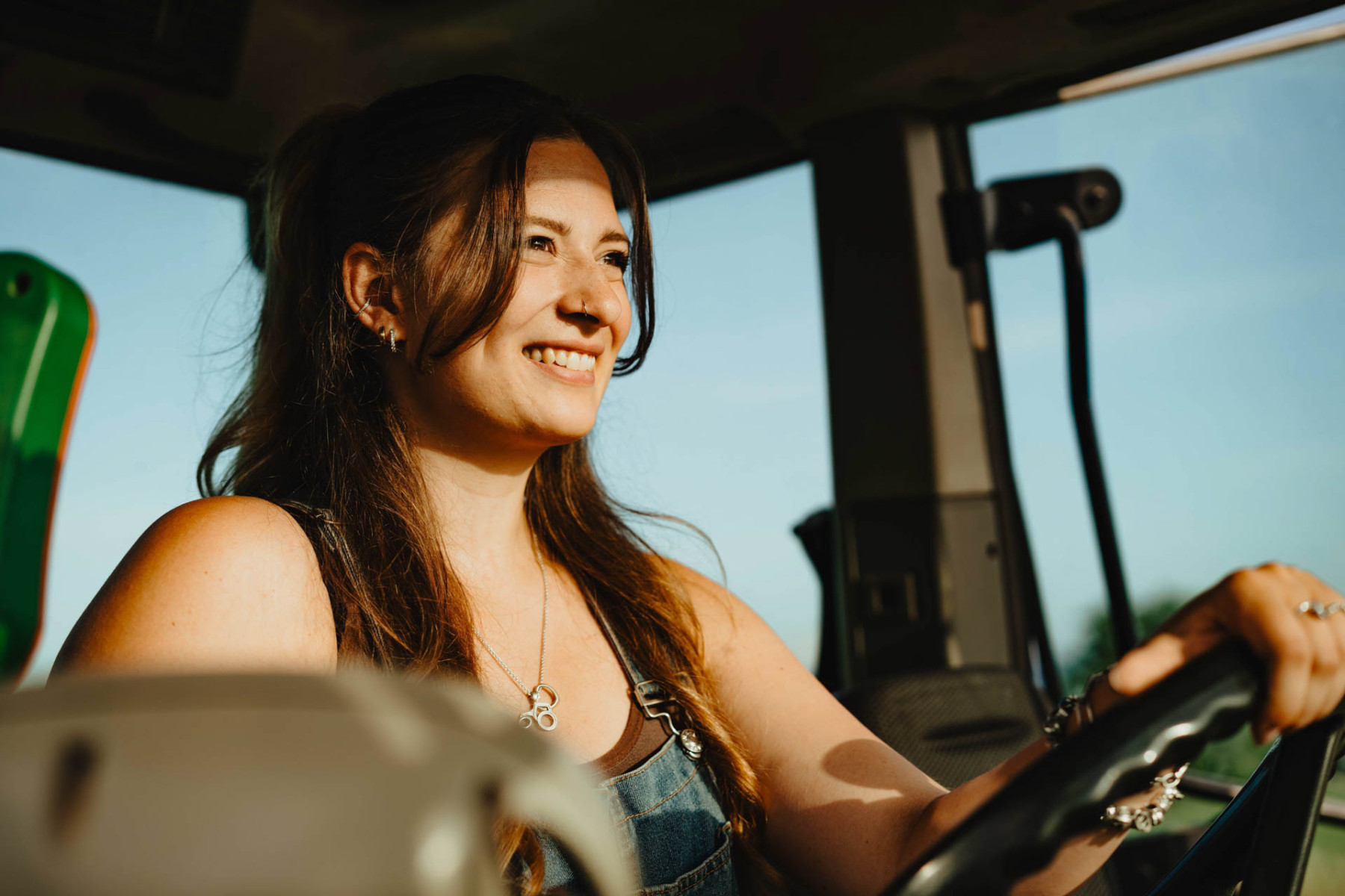 Lisa Dinger fährt lächelnd Traktor.