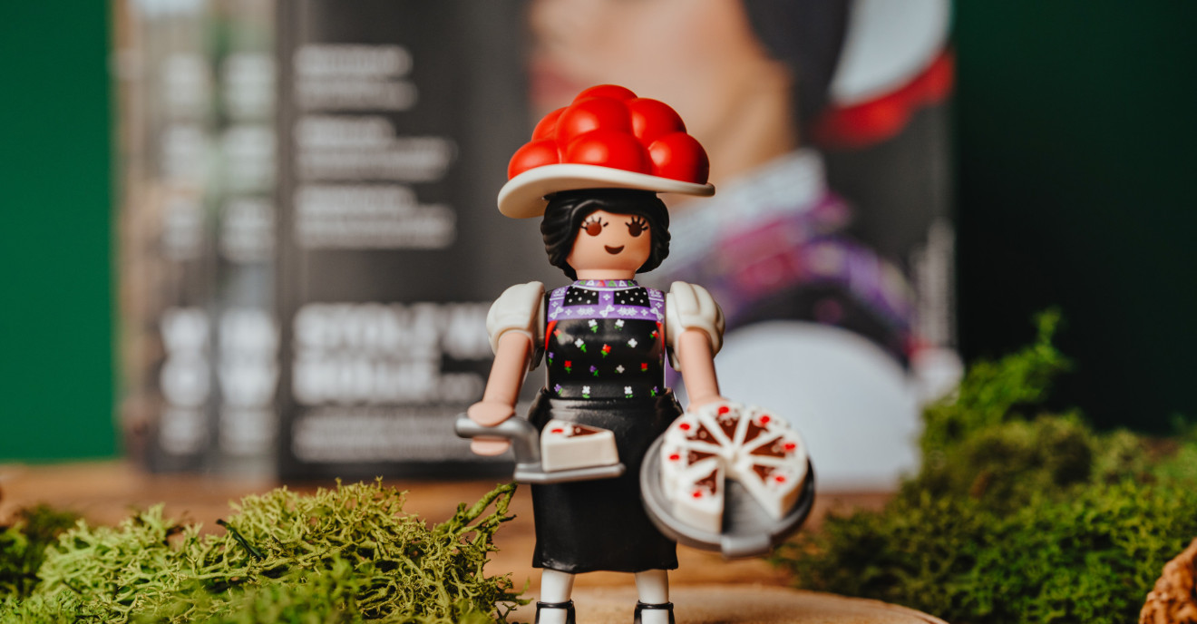 Eine Schwarzwald Marie von Playmobil steht vor einem #heimat-Magazin