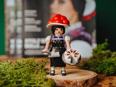 Eine Schwarzwald Marie von Playmobil steht vor einem #heimat-Magazin