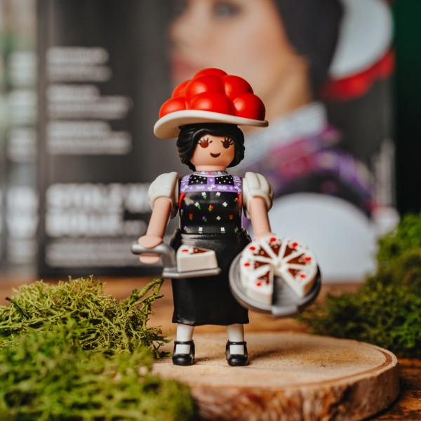 Eine Schwarzwald Marie von Playmobil steht vor einem #heimat-Magazin