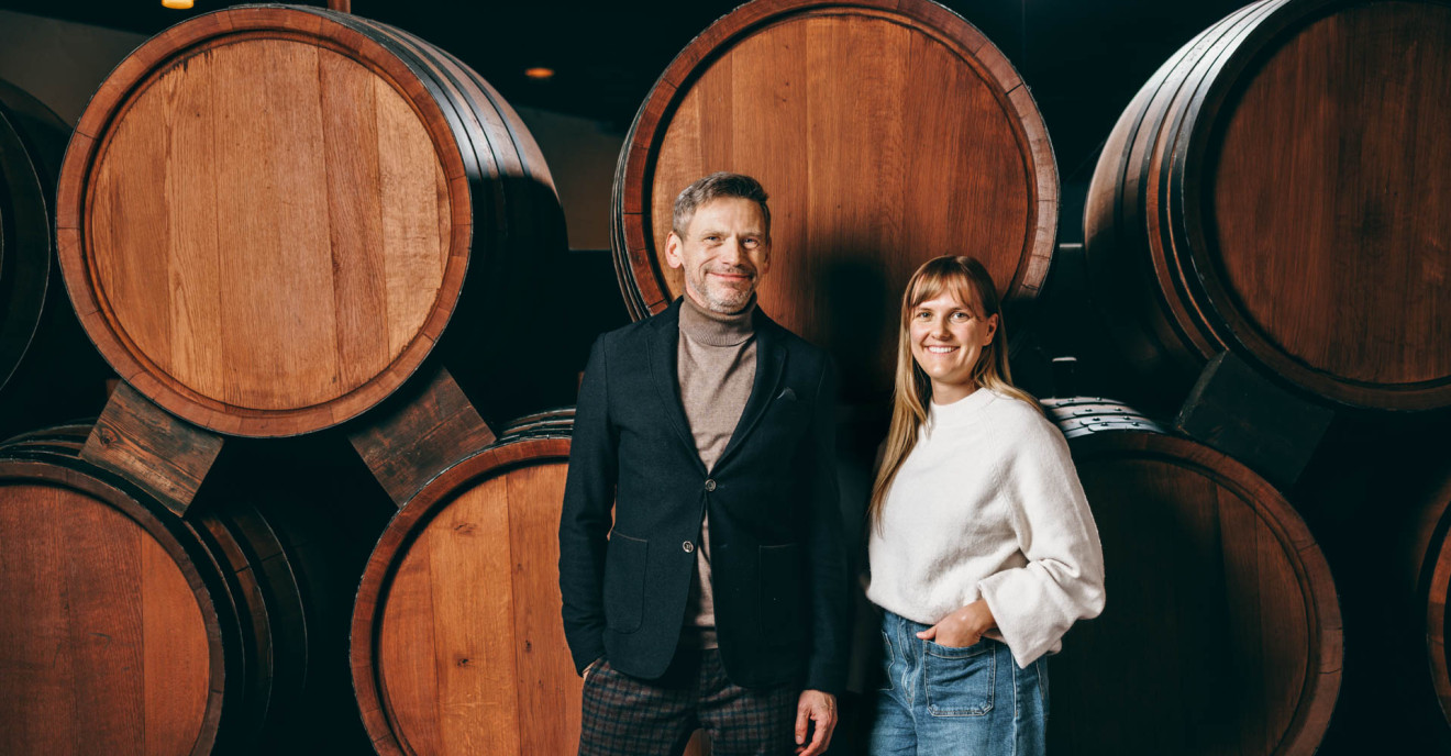 Andre Weltz und Lea Tritschler vor Weinfässern.