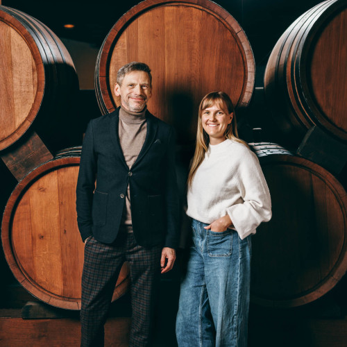 Andre Weltz und Lea Tritschler vor Weinfässern.