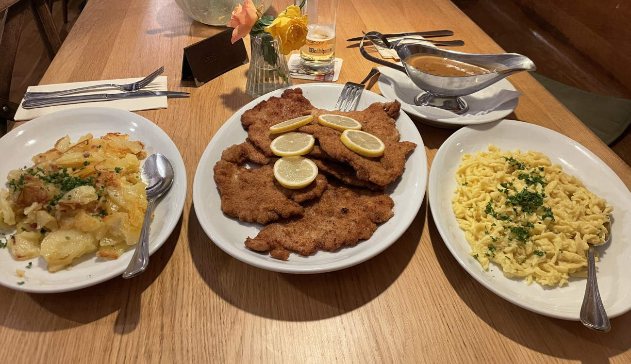 Mehrere Teller, einer davon mit fünf Schnitzel und Zitronen