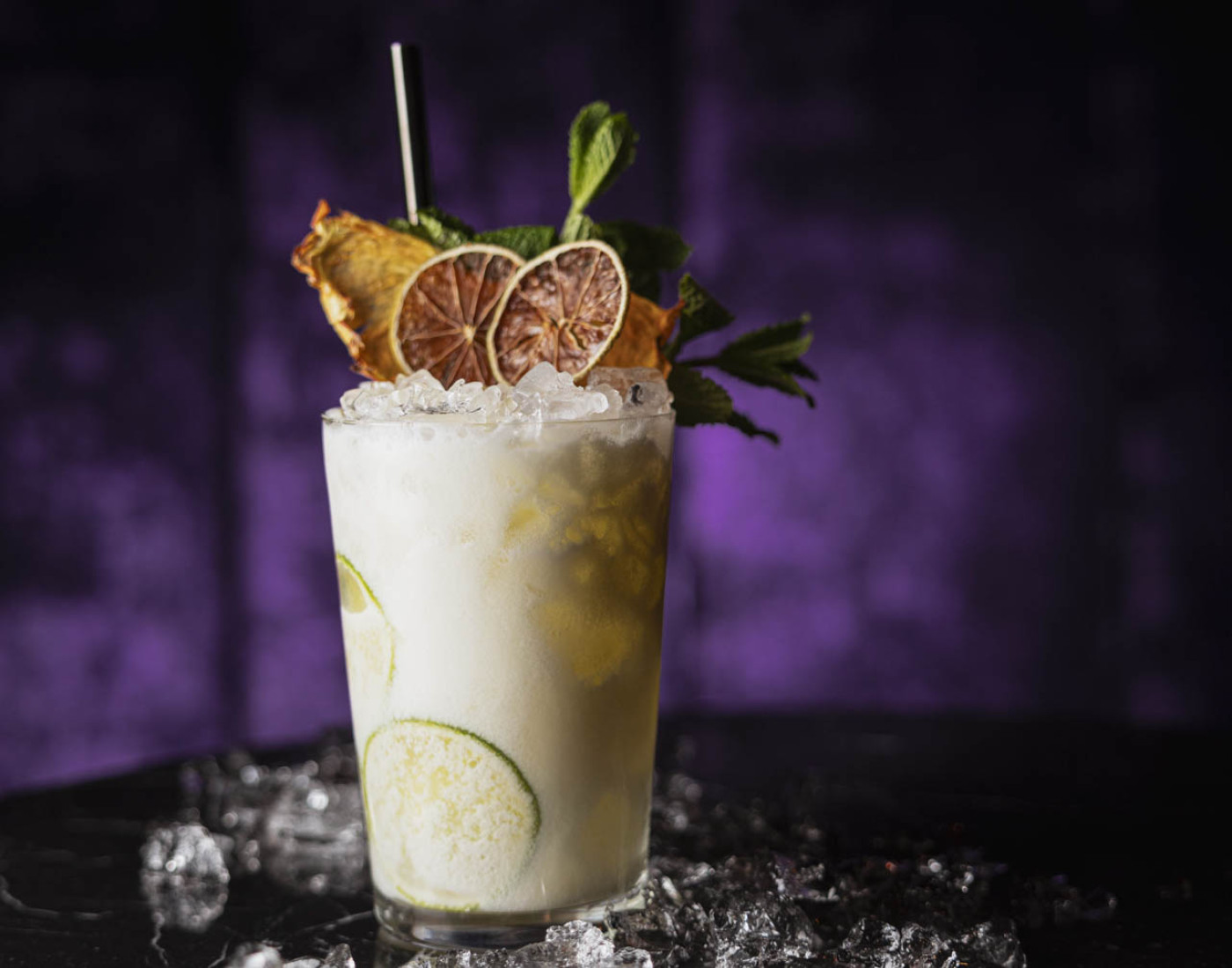 Eine cremige, helle Flüssigkeit in einem Cocktailglas mit Crushed Ice.