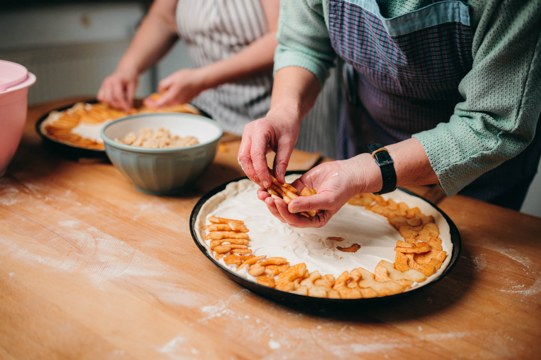 Ein süßer Apfelkuchen wird mit Äpfeln belegt.