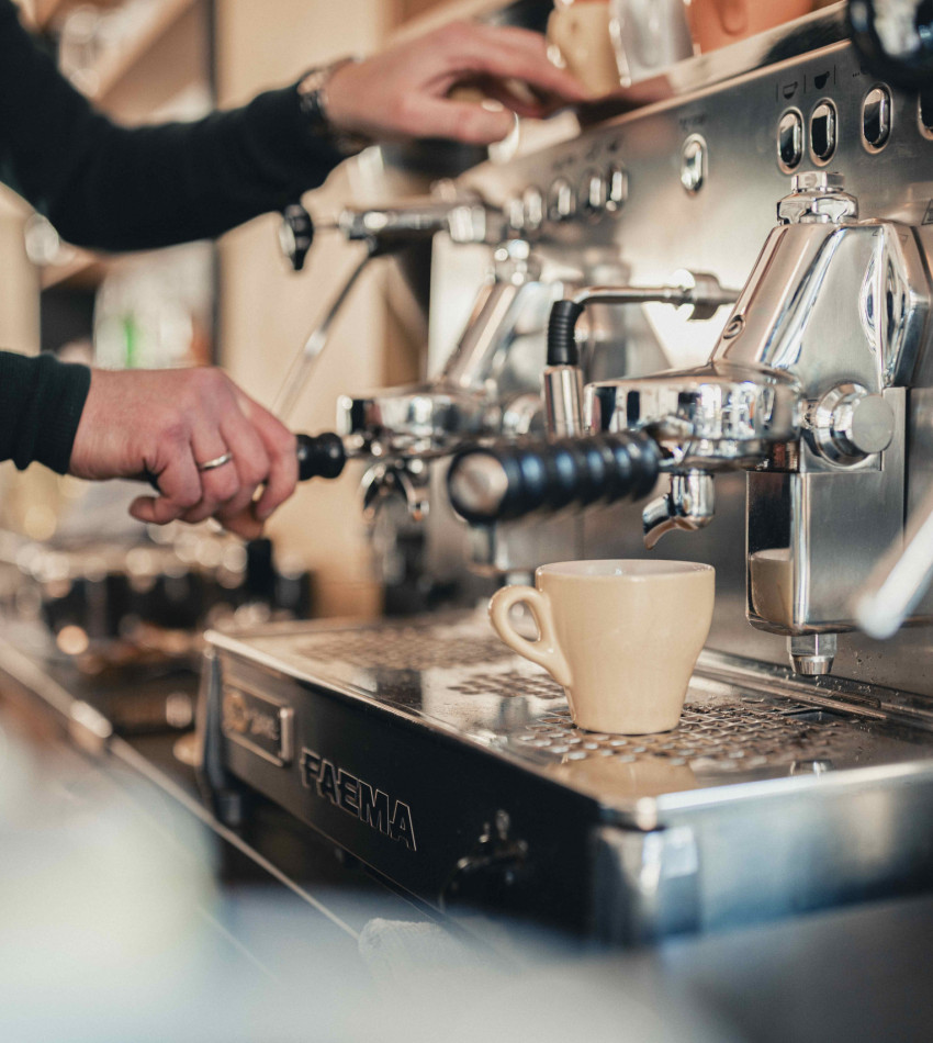 An der italienischen Siebträgermaschine wird gerade Kaffee gemacht