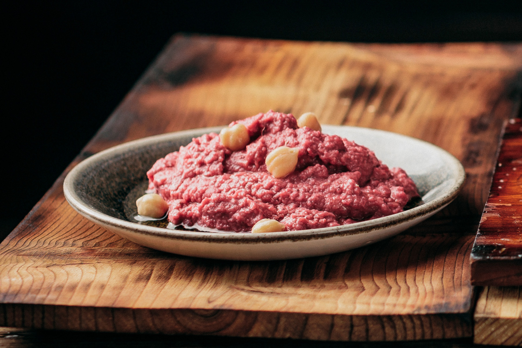 Rote-Bete-Hummus auf einem grauen Teller 