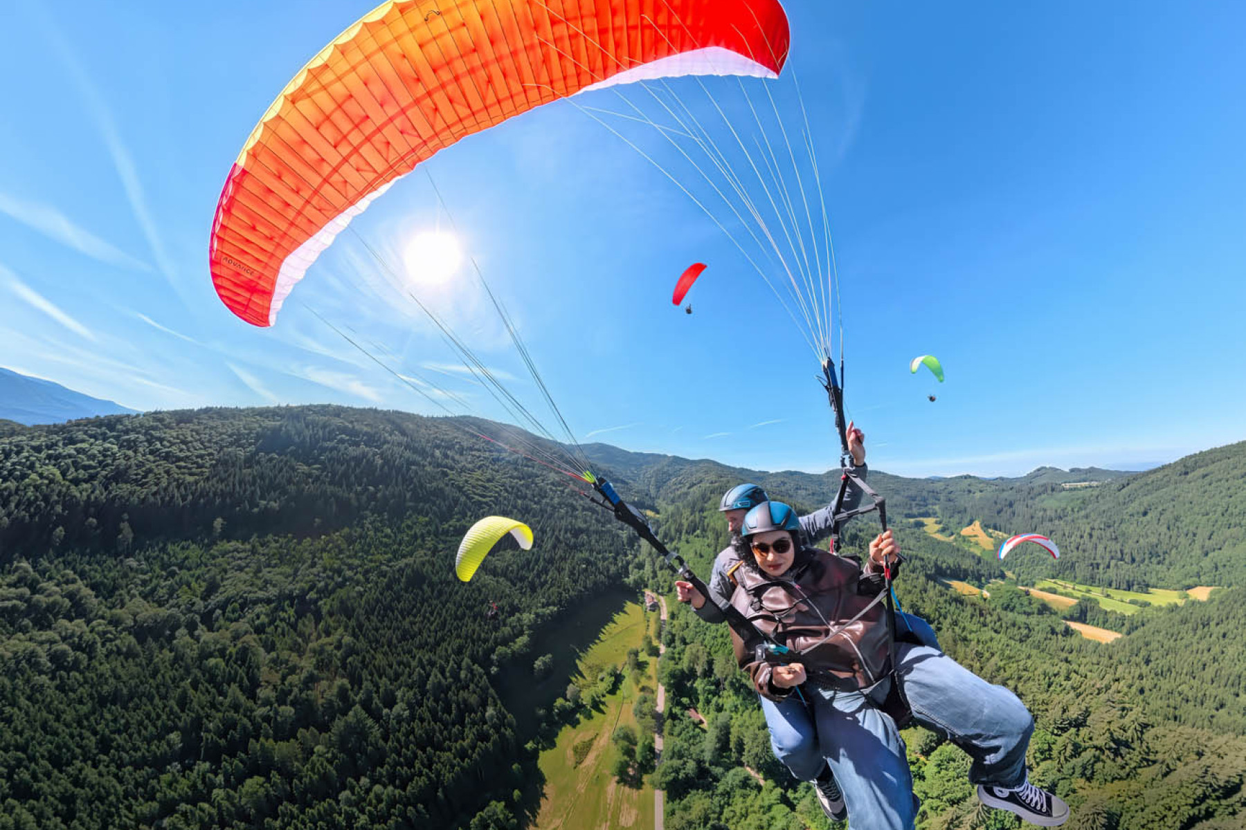 Zwei Personen gleiten bei einem Tandemflug durch die Luft.