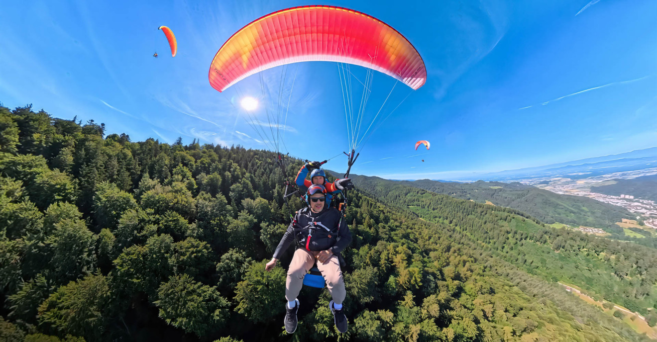 Zwei Personen gleiten bei einem Tandemflug durch die Luft.
