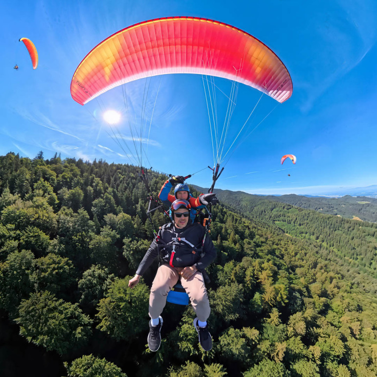 Zwei Personen gleiten bei einem Tandemflug durch die Luft.
