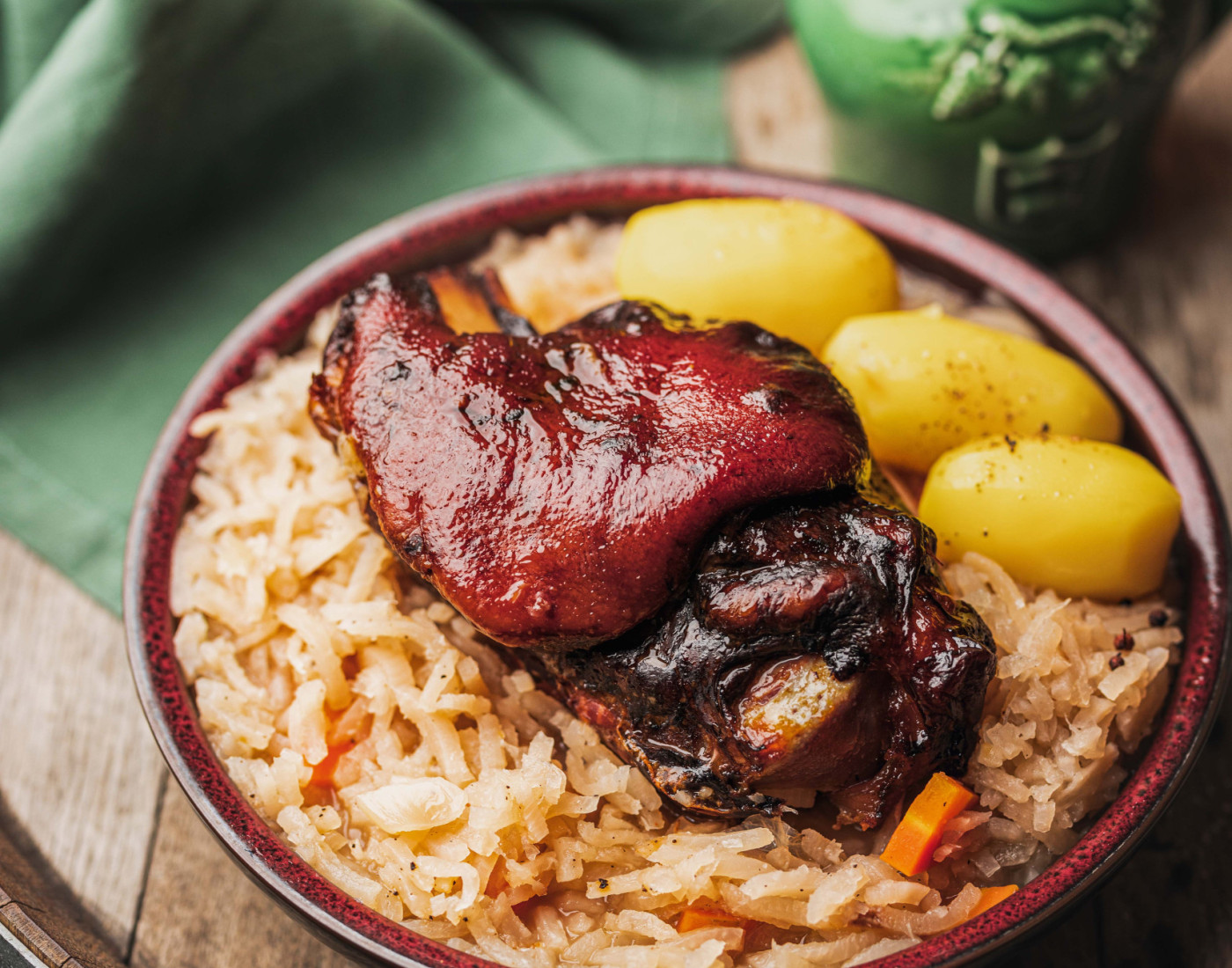 Sauerrüben mit Fleisch und Knödel auf einem braunen Teller, serviert auf einem Holzfass 