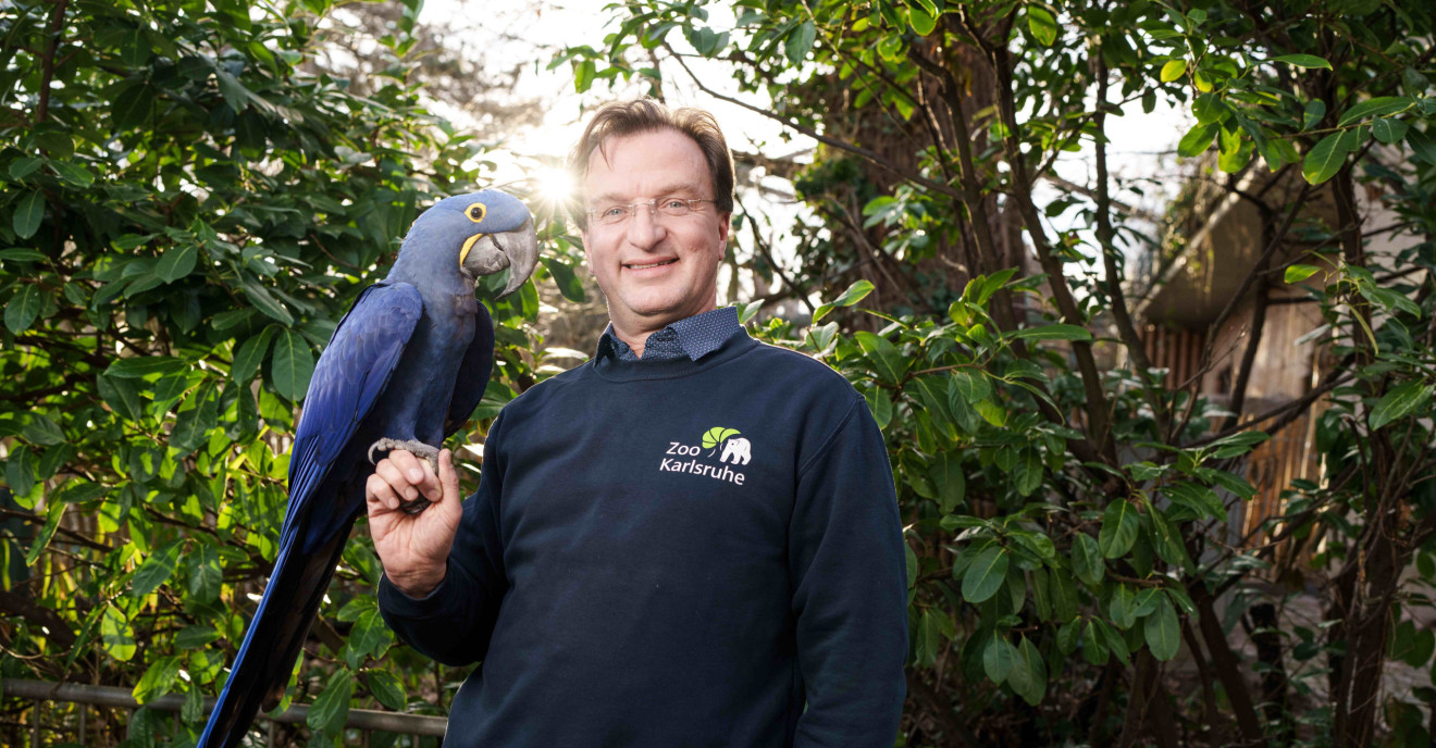 Matthias Reinschmidt mit einem Papagei 