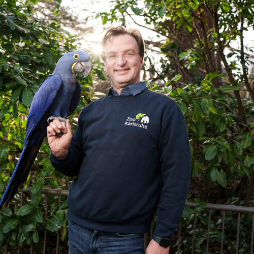 Matthias Reinschmidt mit einem Papagei 
