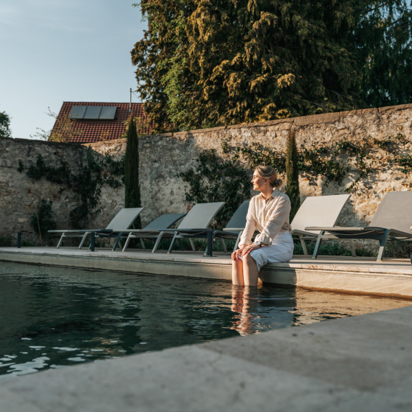 Eine Frau sitzt am Pool des Hotels