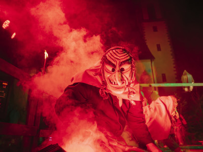 Eine Hexe tanzt zur Fastnacht im Dunkeln auf einer rot beleuchteten Bühne